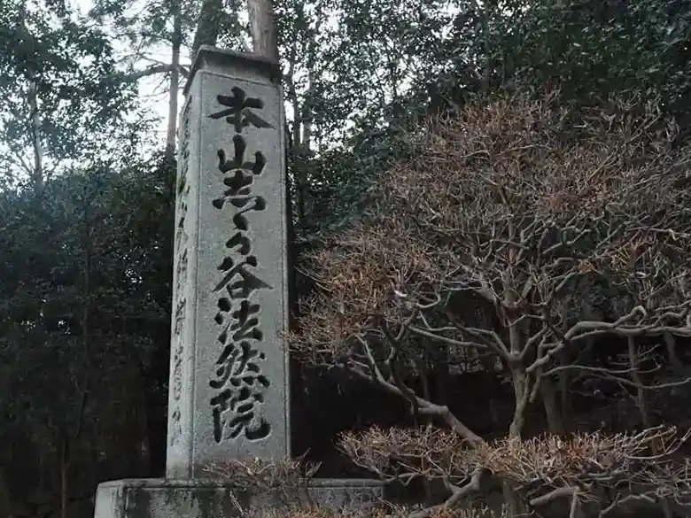 This picture shows a white stone monument about 2 meters high standing at the entrance to Honen-in. The inscription on the surface reads "Honzan Shikagaya Honen-in.
