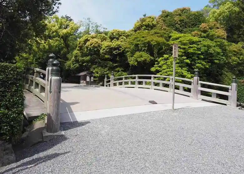 This photo shows the Hiyokebashi Bridge at Geku of Ise Grand Shrine. This bridge spans the Horikawa River, which flows into the sacred area of the shrine. At the bridge entrance, there is a signboard that says, "Passage on the left. From this point onward, worshippers must pass on the left side of the road, as the deities pass in the center of the path.