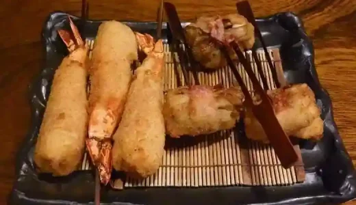 This photo shows three shrimp Kushiage, and three maitake mushroom Kushiage served on a brown square plate.