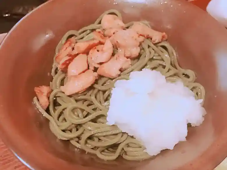 This photo shows grated radish and buckwheat noodles. Tea soba noodles served with grated radish. These noodles are made by kneading matcha green tea into buckwheat flour.