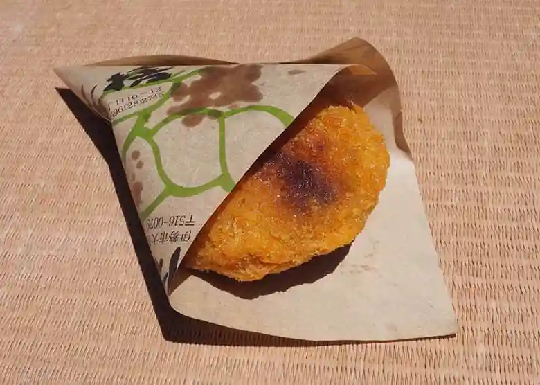 This photo shows croquettes purchased from Butasute. The croquettes are wrapped in brown paper.