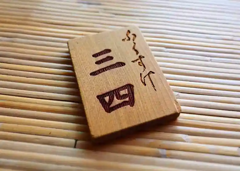 This picture shows a numbered tag from an Ise Udon restaurant called Fukusuke. The name "Fukusuke（ふくすけ）" and the number "34（三四）" are carved into a wooden board in Japanese.