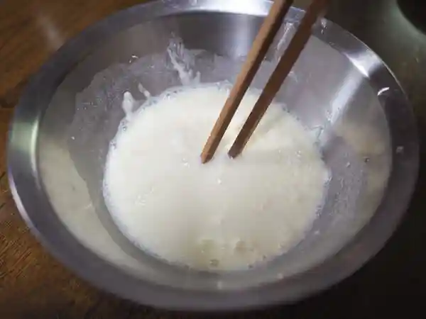 水に加えた天ぷら粉を混ぜている写真です。
