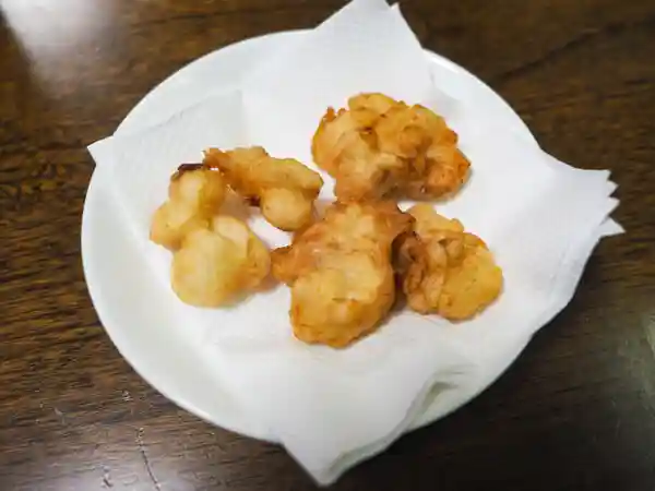 白子の天ぷらの写真です。6個の天ぷらが白い皿に盛られています。天ぷらの大きさは一口大です。