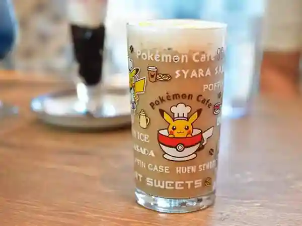 This picture shows a Halloween marron latte with Pikachu. The glass has a picture of Pikachu in a coffee cup. 
