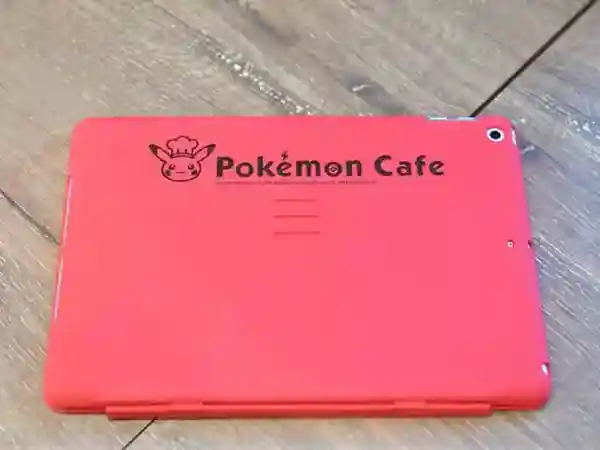 This photo displays the red cover of a tablet. On the front of the device is a Pikachu depicted in a chef's outfit, complete with a cook's hat.
