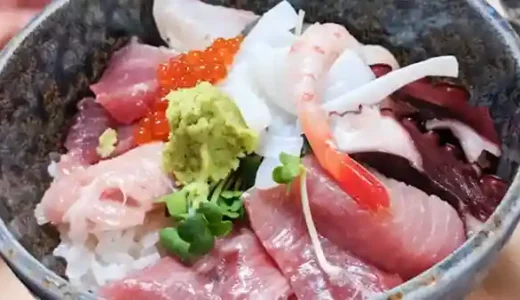 This picture shows a Sashimi rice bowl served in a bowl of rice with thick slices of sashimi. Sashimi includes tuna, bonito, yellowtail, salmon roe, squid, octopus, and sweet shrimp.