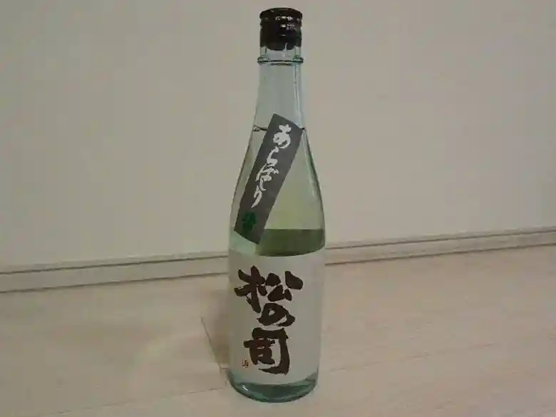 This photo shows a bottle of Matsu no Tsukasa's Junmai Ginjo Arabashiri purchased at Izumiya Ichiko Shoten. The sake comes in a light blue four-quart bottle.