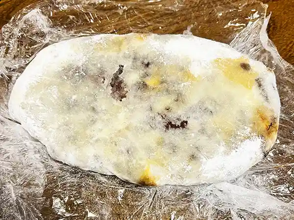 ラップを剥がしたシュトレンの底面の写真です。シュトレンの底面にはバターが滲み出ています。