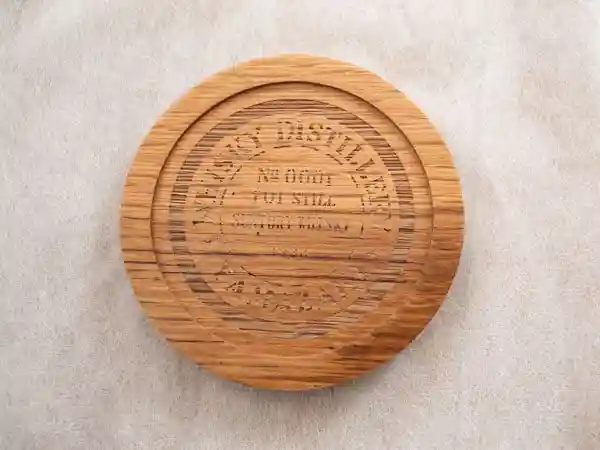 This photo shows a barrel oak coaster purchased at the gift store of the Whiskey Museum at Suntory Yamazaki Distillery. This coaster is made from dismantled barrels used for maturing whiskey.