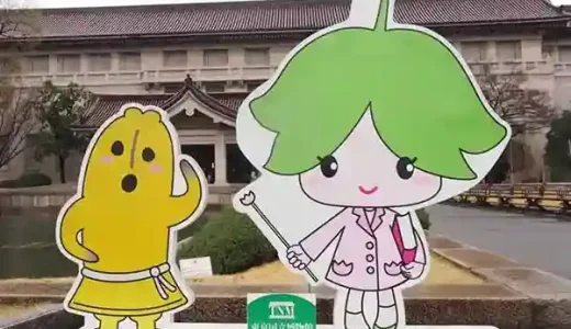 This photo shows a sign in the shape of "Tohaku-kun" and "Yurinoki-chan," the official characters of the Tokyo National Museum. This signboard is standing at the entrance of the Tokyo National Museum. On the left is the 50cm-tall Tohaku-kun, and on the right is the 1m-tall Yurinoki-chan. Tohaku-kun is a terra-cotta tombstone modeled after the "Dancing Haniwa" in the museum's collection. Yurinoki-chan is a girl whose motif is based on the flower of the "Yurinoki" tree in front of the main building.