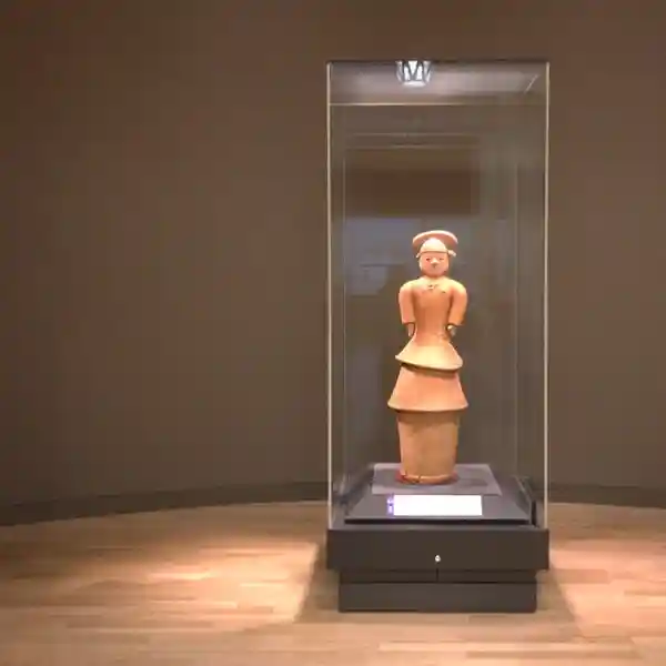 This photo shows the whole body of a haniwa named "Woman in full dress." She is 126.5cm tall and wears a necklace, earrings, ear beads, and a cue ball. It is rare to see a Haniwa in such a full dress, which is thought to be a copy of a high-ranking woman's attire.