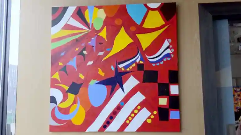 「J_O CAFE」に飾られた絵画の写真です。1辺が2mほどの赤色を基調にした大きな作品です。