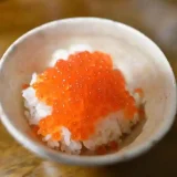 生筋子の醤油漬けで作ったイクラ丼の写真です。白い茶碗によそったご飯の上に真っ赤な生筋子の醤油漬けが盛られています。