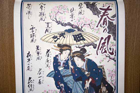 平成30年版の笑点暦の3月と4月の頁の写真です。桜の花が舞い散る中を歩く、着物姿の二人の女性が浮世絵で描かれています。