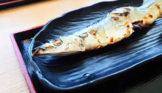 秋刀魚の塩焼きの写真です。黒い皿に表面が焦げた秋刀魚の頭側半分が写っています。北海道釧路産の新秋刀魚です。