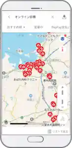 スマートフォンの画面に表示されたYahoo! MAPアプリの写真です。オンライン診療に対応している医療機関の場所が赤丸で表示されています。