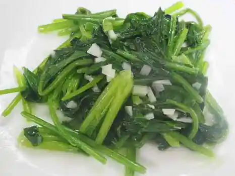 お皿に盛ったほうれん草とにんにくです。鮮やかな緑色にできあがりました。