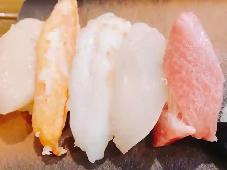 お寿司の写真です。ホタテ貝とカニ、イカ、マグロのにぎりです。