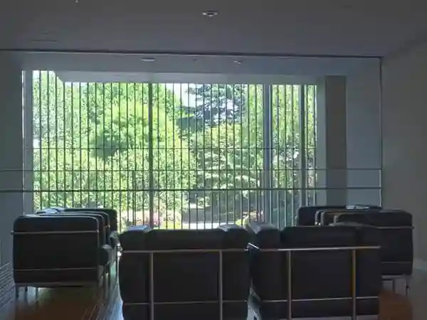 This photo shows sofas in the reference room on the second floor of the Gallery of Horyuji Treasures. When you sit on the couch, you can see the trees in the garden through the glass wall in front of you.