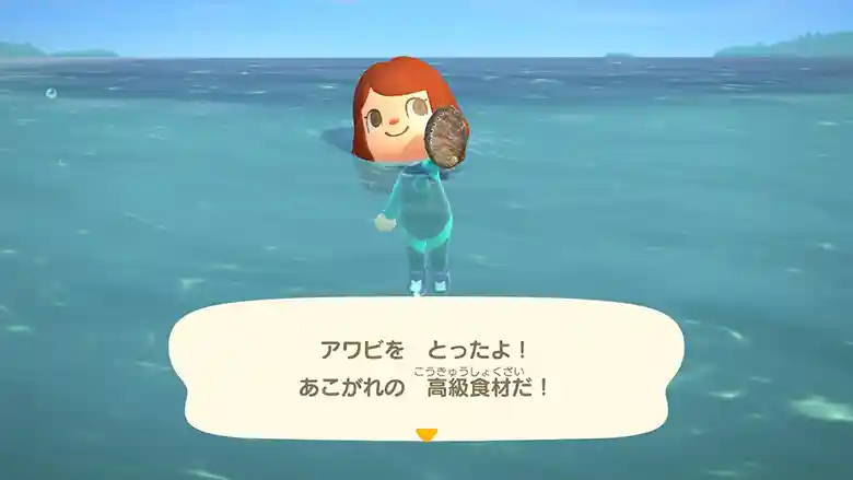 任天堂の「あつまれどうぶつの森」のゲーム画面の写真です。マリーンスーツを着た女の子が海に浮いています。アワビを持った左手を前に突き出しています。画面の下方に「アワビをとったよ！あこがれの高級食材だ！」と文字が出ています。