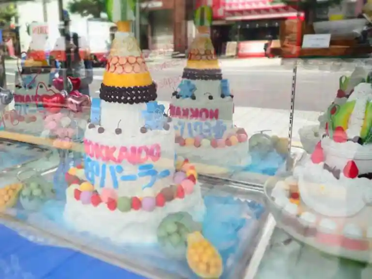 雪印パーラーのショーケースの写真です。大きい色鮮やかなケーキやパフェが並んでいます。